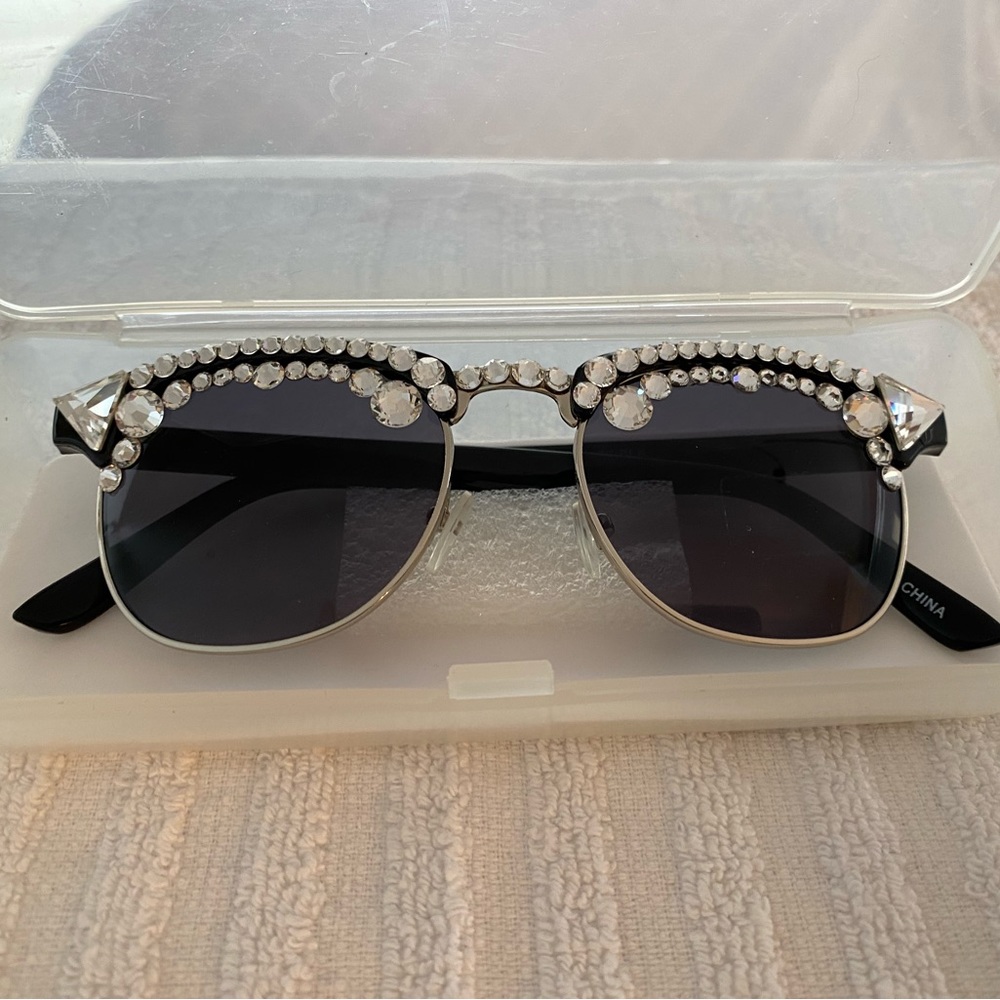 This is a pair of crystal adorned sunglasses in black frame and lens
